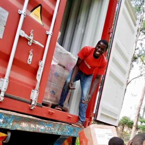 Kenya, Africa smiling child unloading a truck